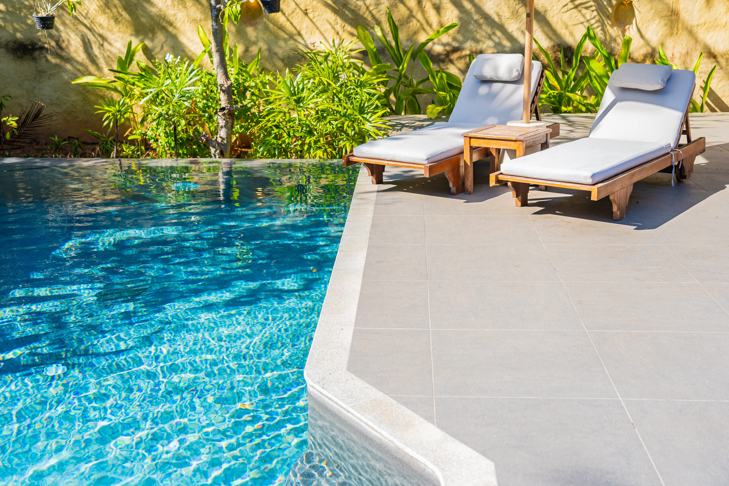 Umbrella and chair around outdoor swimming pool